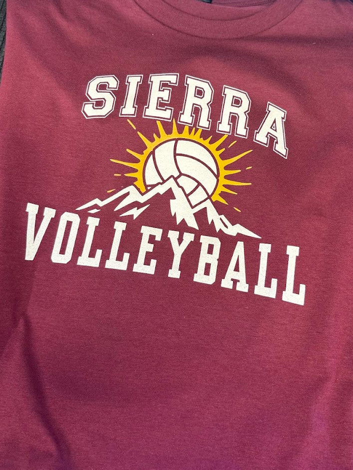 A maroon short-sleeve t-shirt featuring a 'SIERRA VOLLEYBALL' graphic on the chest with a white volleyball, yellow sunburst, and white mountain silhouette.