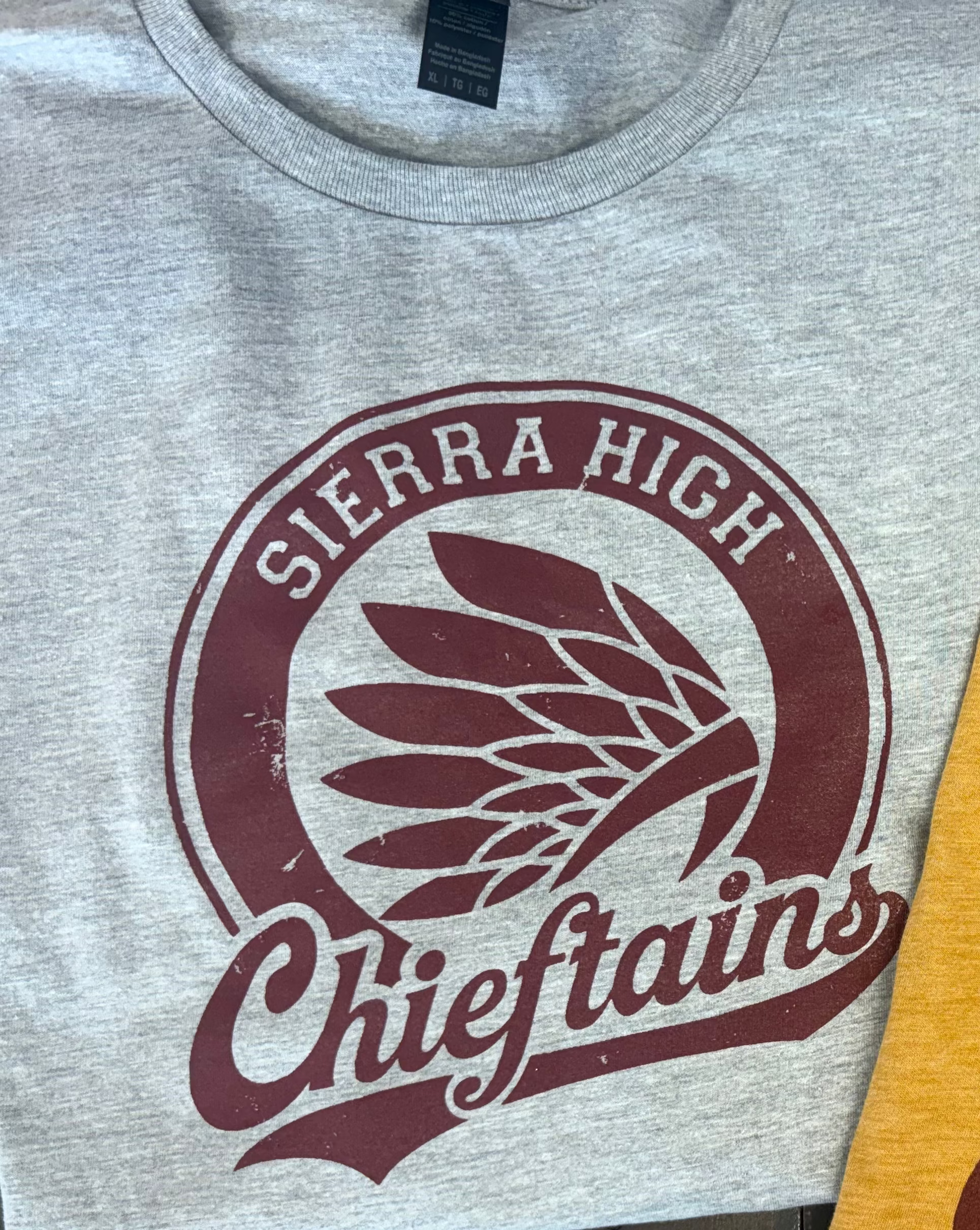 Close-up of a heather gray t-shirt featuring a maroon graphic print with the words 'Chiefs' and 'SIERRA HIGH' surrounding a central agave leaf design.